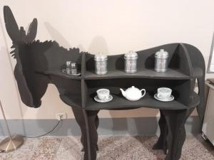 Una mesa negra con tazas y teteras. en Rosa'villa 9, en Murazzano