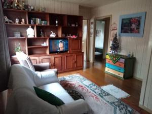 sala de estar con sofá y TV en Casa da vovó, en Gramado