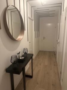 a hallway with a table and a mirror on the wall at PENTHOUSE Terrasse Jacuzzi 6 voyageurs in Le Blanc-Mesnil