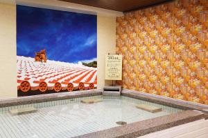 a swimming pool with a large painting of a train at Almont Hotel Naha Omoromachi in Naha