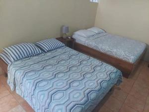 dos camas sentadas una al lado de la otra en un dormitorio en Evan Room, en Quepos