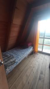 uma pequena cama num quarto com uma janela em Don Cleto em Aiguá