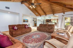 a living room with leather furniture and a wooden ceiling at Sunset Retreat- TWO houses with hot tub, firepit, multiple kitchens, sleeps 20 in Coarsegold +56 photos
