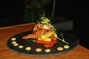 une assiette de nourriture avec du poisson et des carottes sur une table dans l'établissement Hotel Casa HX - Adults Only, à Holbox