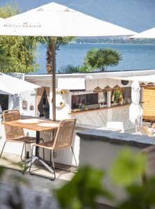 Riva Beach Club I Boutique Hotel I Restaurant في فيرا: طاولة وكراسي مع مظلة والمحيط
