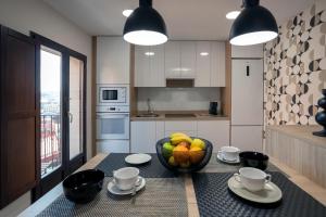 a kitchen with a bowl of fruit on a table at El Arco San Esteban by Unique Rooms in Burgos