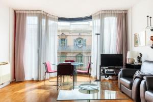 a living room with a table and pink chairs at Comodidad y elegancia a lado de la Diagonal in Barcelona