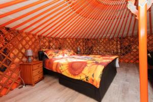 Colourful Mongolian Yurt enjoy a new experience في Turriff: غرفة نوم بسرير في خيمة
