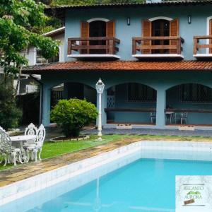 a house with a swimming pool in front of a house at Hostel Recanto Aurora in Petrópolis