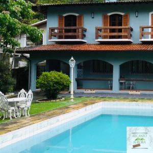 ein Haus mit einem Pool vor einem Haus in der Unterkunft Pousada Recanto Aurora in Petrópolis