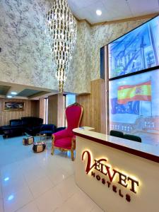 a hotel lobby with a red chair and a chandelier at Velvet Hostels in Madrid