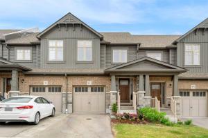 a house with a car parked in front of it at Konia Suites in Orangeville