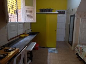 uma cozinha amarela com um balcão e uma janela em Kitnet Mobiliada em São Luís
