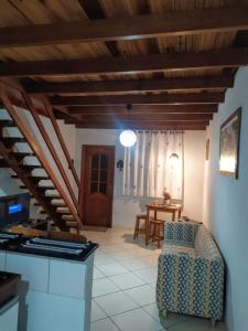 a living room with a staircase and a chair at Chalé da Lu in Santo Antônio do Pinhal