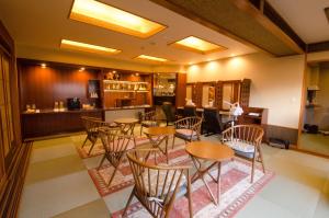 a restaurant with tables and chairs and a bar at Inatori Tokai Hotel Yuen in Higashiizu