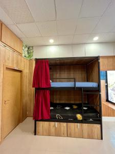 Pokój z 2 łóżkami piętrowymi z czerwoną zasłoną w obiekcie Velvet Hostels w Madrycie