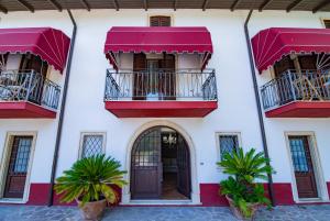 un edificio blanco con balcones rojos y una puerta en Villa Vitti's - Verona est en San Martino Buon Albergo