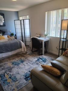a bedroom with a bed and a couch and a table at Levander Cozy Home in Alhambra