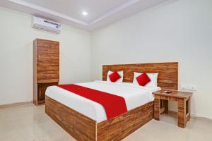 um quarto com uma cama grande e almofadas vermelhas em OYO Flagship 81135 Hotel R Square Inn em Hyderabad