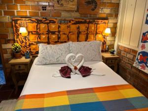 a bed with two heart shaped towels on it at Hotel Pousada Praia do Farol in Ilha do Mel