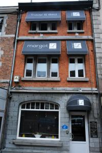 a brick building with windows and a store at MARGOT'L in Rochefort