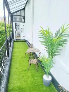 a balcony with a table and chairs and a plant at Prime London Living 2-Bedroom Beauty! in London