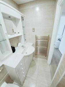 a white bathroom with a sink and a toilet at Prime London Living 2-Bedroom Beauty! in London