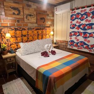 um quarto com uma cama com um cobertor colorido em Hotel Pousada Praia do Farol na Ilha do Mel