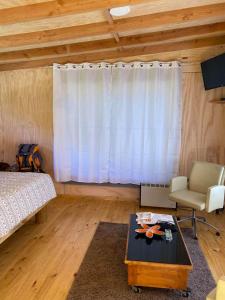 1 dormitorio con cama, mesa y ventana en Cabañas Mi Refugio Puerto Varas, en Puerto Varas