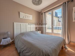 a bedroom with a bed and a large window at Maison 3 chambres, accès plage direct, proche centre et commerces - FR-1-197-550 in Les Sables-dʼOlonne