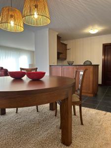 a living room with a wooden table and a kitchen at Villa Deluxe - Quinta do Outeirinho in Celorico de Basto