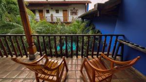Duas cadeiras sentadas numa varanda com piscina em Miss Margrits em Granada