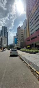 un coche blanco conduciendo por una calle en una ciudad en Lindo Apt em Boa Viagem en Recife