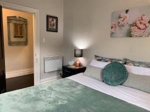 Un dormitorio con una cama grande con una almohada verde. en Roslyn Business Studio - 2 bedroom, en Dunedin