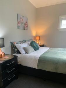 een slaapkamer met een bed met kussens erop bij Roslyn Business Studio - 2 bedroom in Dunedin
