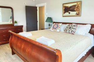 1 dormitorio con 1 cama grande y espejo en Coco home, en Charlottetown