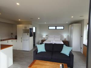 ein Wohnzimmer mit einem Sofa und einem Bett in der Unterkunft Vineyard Vacation in Mangawhai