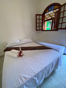 um quarto com 2 camas e uma janela em Pousada por do soll em Serra do Cipó