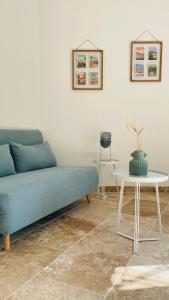 een woonkamer met een blauwe bank en een tafel bij Le bastidon - Fontvieille in Fontvieille