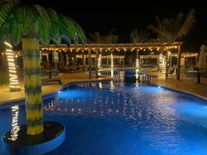 a large swimming pool with a resort at night at Ancla 201 Departamento Familiar in Altata