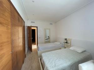a small bedroom with two beds and a mirror at Atlantic Magna in Tangier