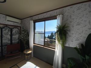 a room with a window and a potted plant at 森の中富士山見える部屋202 in Hakone