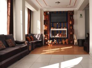 a living room with a couch and a tv at CESAR'S HOTEL PERU in Puno