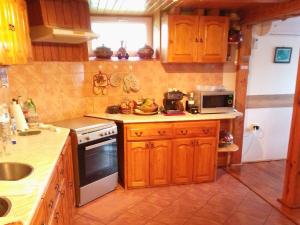 uma cozinha com armários de madeira e um forno com placa de fogão em Apartment Nina a beauty stay in Bulgaria em Kramolin