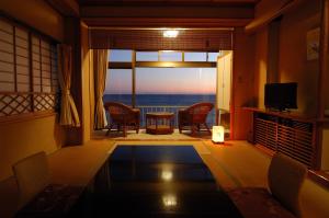 a living room with a view of the ocean at Inatori Tokai Hotel Yuen in Higashiizu