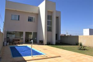 una casa con piscina frente a ella en Sobrado espaçoso com piscina com ar na suite, en Chapada dos Guimarães