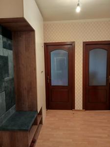 2 puertas de madera en una habitación con suelo de madera en Квартиры Уют в Туркестане, en Türkistan