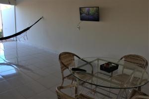 una mesa de cristal y sillas en una habitación en Casa com 03 quartos tendo 02 com ar condicionado no asfalto a 1,5 km do centro, en Chapada dos Guimarães