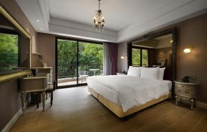 een slaapkamer met een groot bed en een groot raam bij 格拉斯行館 Grasse Grace Manor in Nanzhuang
