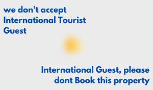 a sign that says we dont accept international tourist dont book this property at Homey Guesthouse Kertajaya (Syariah) in Surabaya